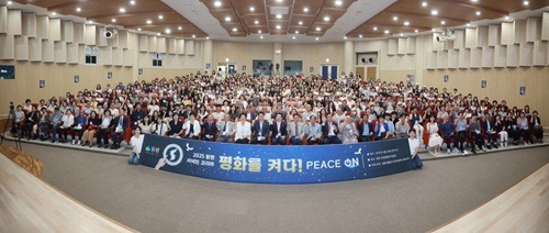 2_참석자_모두_12일_2025_동행_평화를_켜다_Peace_ON!_행사에서_빛_퍼포먼스에_참여하고_있다.jpg
